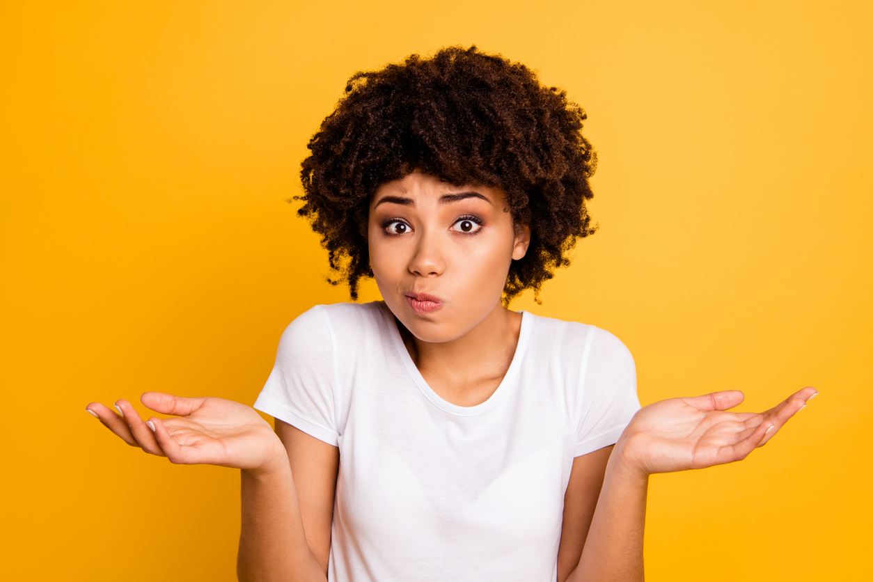 Young Woman Shrugging Against Yellow Background